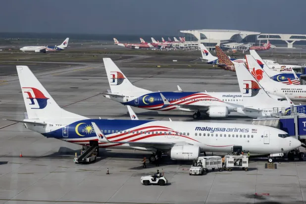 Sepang’daki Kuala Lumpur Uluslararası Havalimanı’nda Malezya Havayolları uçağına bagajları yükleyen işçiler (EPA)