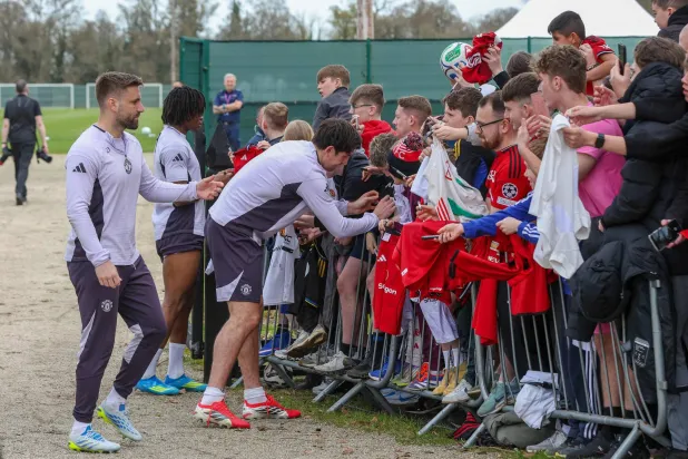 نجم يونايتد وإنجلترا يوقع على قمصان مجموعة من المشجعين والأطفال (أ.ف.ب)