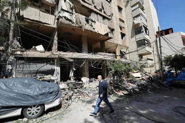 A Lebanese man walks past destruction at the site of an Israeli airstrike the day before that targeted a building in Beirut on April 9, 2026. (Photo by Ibrahim AMRO / AFP)