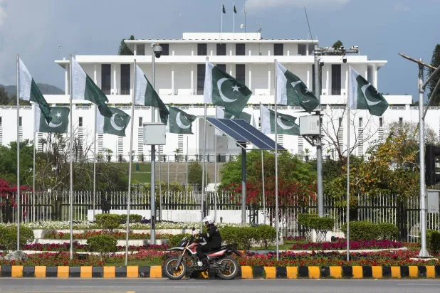 A man rides a motorcycle past the President house as Pakistan gears up to host the US and Iran for peace talks, in Islamabad, Pakistan, April 9, 2026. REUTERS/Waseem Khan