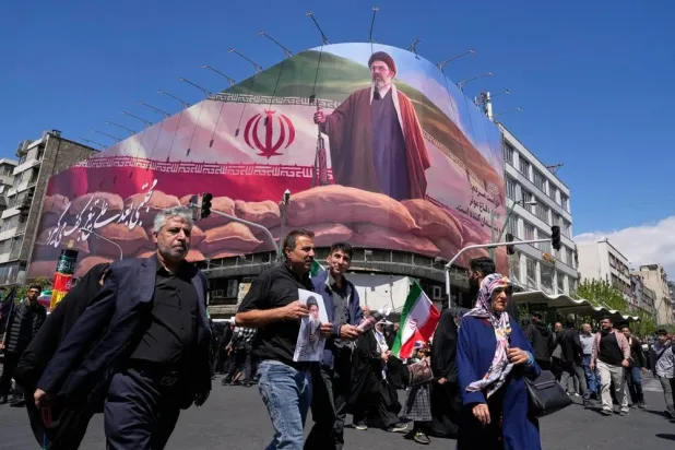  Government supporters walk past a billboard depicting Iran's Supreme Leader Mojtaba Khamenei as they gather to mark the 40th day since the killing of his father, slain Supreme Leader Ali Khamenei, in Tehran, Iran, Thursday, April 9, 2026. (AP) 