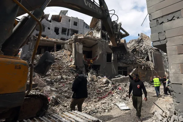 جرافة تزيل أنقاض مبنى دمرته غارات إسرائيلية على ضاحية بيروت الجنوبية (إ.ب.أ)