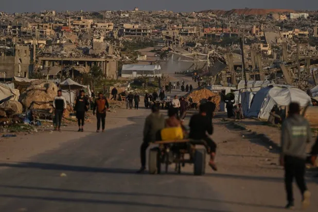  Palestinians walk along a street surrounded by buildings destroyed during Israeli air and ground operations in Khan Younis, southern Gaza Strip, Thursday, April 9, 2026. (AP) 
