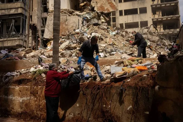 Residents search for belongings in the rubble of a building hit by an Israeli strike in the Ain el-Mreisseh area of Beirut (Reuters) 
