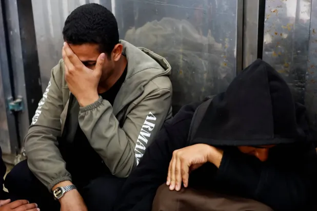  Gazze Şeridi’nin orta kesimindeki Deyr el-Balah’ta İsrail’in düzenlediği hava saldırısında hayatını kaybedenlerin cenaze töreninde göz yaşı döken iki Filistinli, 11 Nisan 2026 (DPA)