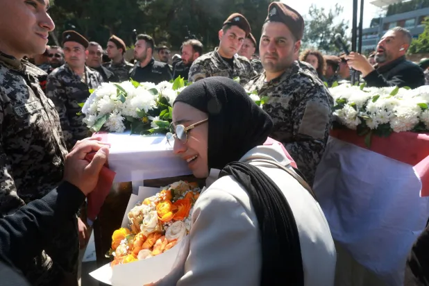 لبنانية وعناصر في أمن الدولة يبكون 13 عسكرياً قُتلوا في استهداف إسرائيلي لمقر «أمن الدولة» في النبطية وشُيّعوا في مراسم عسكرية السبت (رويترز)