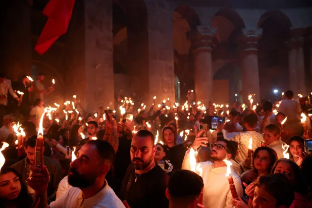 من مراسم إشعال النار المقدسة في كنيسة القيامة بالبلدة القديمة في القدس (رويترز)