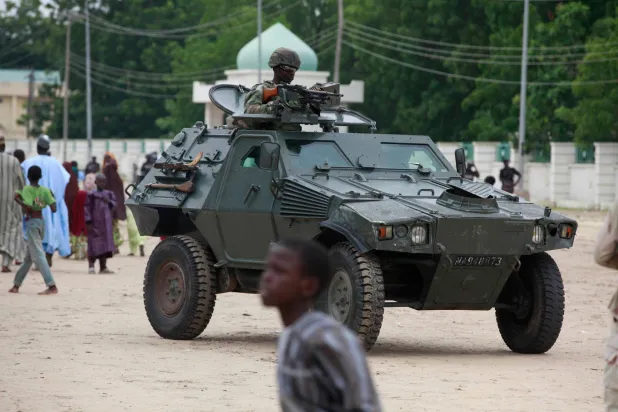 FILE - Nigerian soldiers ride on an armored personnel carrier during Eid al-Fitr celebrations in Maiduguri, in Borno state, Nigeria. Thursday, Aug. 8, 2013. (AP Photo/Sunday Alamba, File)