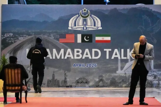 A security officer stands in front of a sign for the Islamabad talks outside a media center set up to cover negotiations between the United States and Iran (AP)