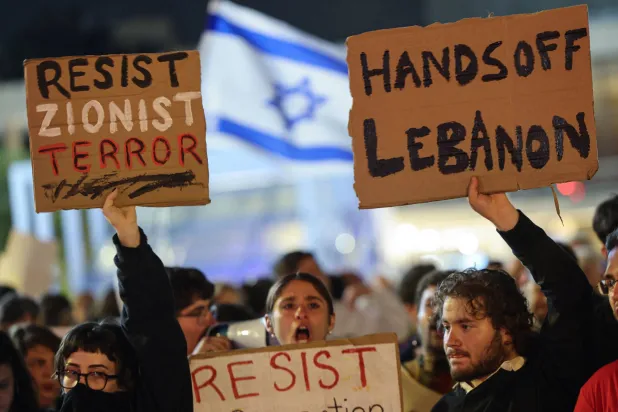 Israeli left-wing activists demonstrate with placards in HaBima Square against the ongoing war with Iran and against the Israeli government in Tel Aviv on April 11, 2026. (AFP)