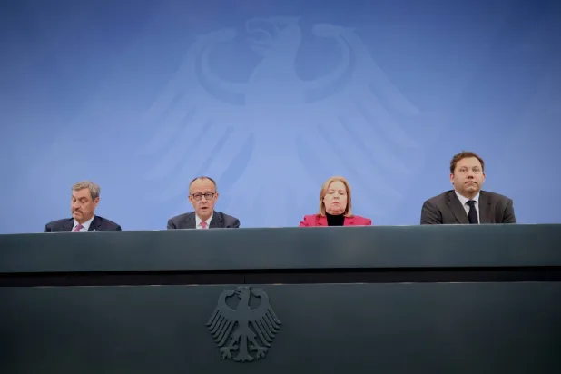 رئيس حكومة ولاية بافاريا ماركوس زودر والمستشار فريدريش ميرتس ووزيرة العمل بربل باس ووزير المالية لارس كلينغبايل خلال مؤتمر صحافي في برلين (إ.ب.أ)