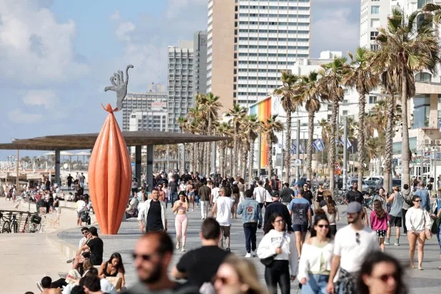 أشخاص يسيرون على طول ممشى بالقرب من الشاطئ في تل أبيب بإسرائيل 8 أبريل 2026 (إ.ب.أ)