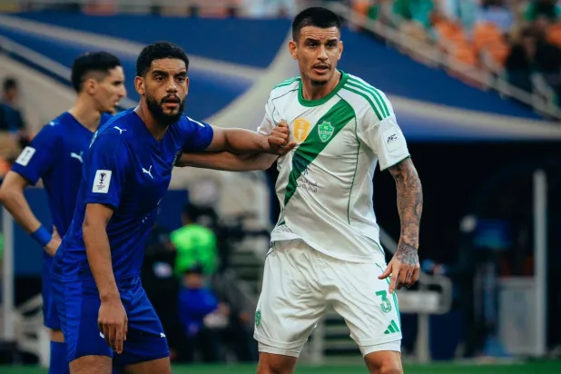 البرازيلي روجر إيبانيز مدافع فريق الأهلي في صراع مع لاعب من الدحيل (النادي الأهلي)