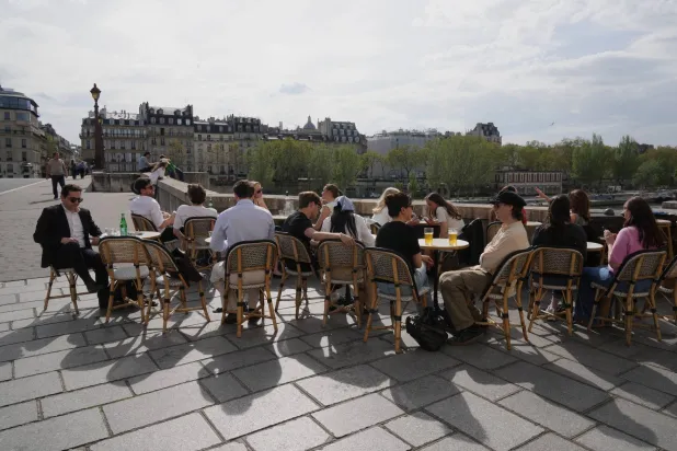 People sit at a bistro, enjoying the sun in Paris, Thursday, April 9, 2026.(AP Photo/Michel Euler)