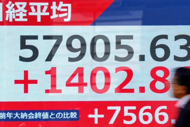 رجل يمر أمام شاشة تعرض حركة الأسهم في وسط العاصمة اليابانية طوكيو (أ.ف.ب)