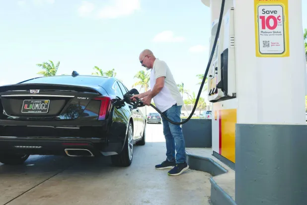 رجل يملأ سيارته بالوقود داخل محطة بنزين في ميامي (أ.ف.ب)