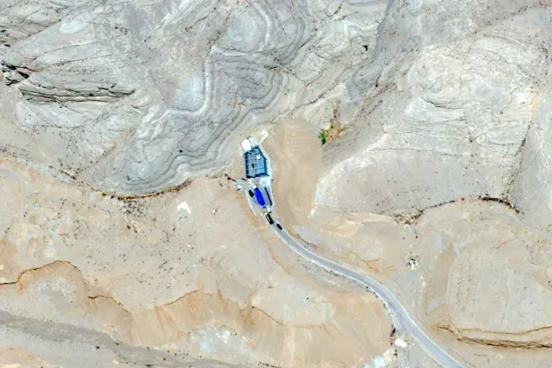 تُظهِر هذه الصورة الملتقَطة بواسطة القمر الاصطناعي «بلياديس نيو» التابع لشركة «إيرباص للدفاع والفضاء» شاحنة محمَّلة بـ18 حاوية زرقاء تنقل يورانيوم عالي التخصيب تدخل إلى نفق داخل مجمع «مركز التكنولوجيا النووية» في أصفهان 9 يونيو 2025 (أ.ب)