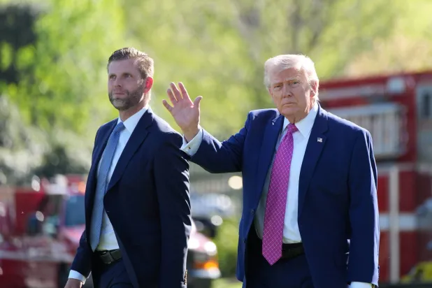 الرئيس الأميركي دونالد ترمب برفقة ابنه إريك يسيران قبل الصعود على متن طائرة في الحديقة الجنوبية للبيت الأبيض (أ.ب)