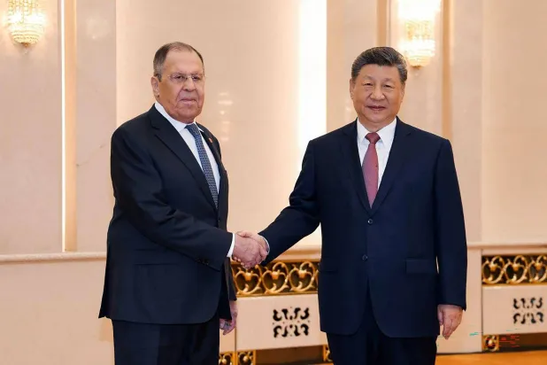This handout picture posted on the Telegram account of the Russian Foreign Ministry on April 15, 2026 shows Russia's Foreign Minister Sergei Lavrov (L) shaking hands with China's President Xi Jinping in Beijing. (Handout / Russian Foreign Ministry / AFP) 