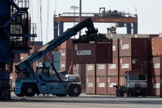 رافعة متحركة تحمل حاوية بميناء دينا دَيال في كاندلا بولاية غوجارات الغربية (رويترز)