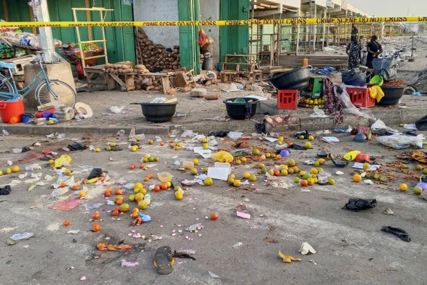 رجال شرطة وسط الأضرار التي لحقت بسوق مدينة مايدوغوري جراء التفجيرات الانتحارية (أ.ب)