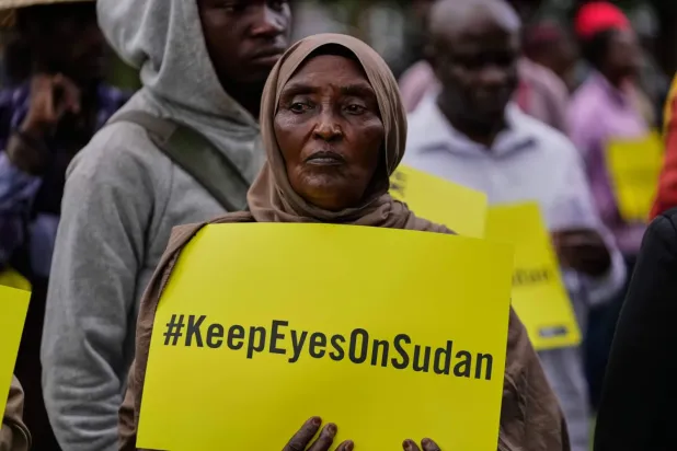 Sudan’daki savaşın dördüncü yıl dönümü münasebetiyle Kenya’nın Nairobi kentinde düzenlenen etkinlikte pankart tutan bir kadın (AP)