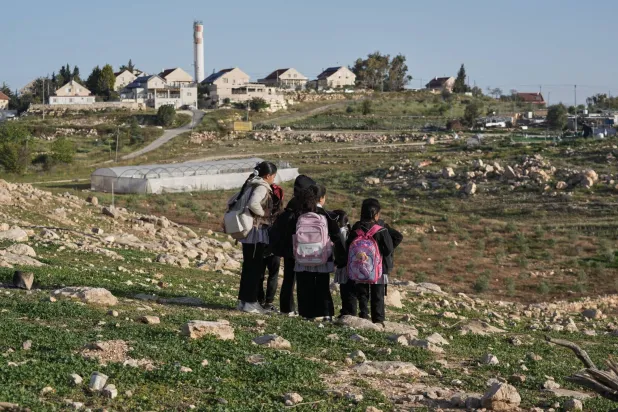  Palestinian students walk to school using an alternative route that is nearly twice as long because a fence separates their village from the nearby Israeli settlement of Carmel, near the West Bank village of Umm al-Khair, Tuesday, April 14, 2026. (AP) 