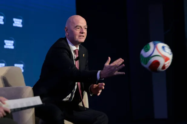 انفانتينو يداعب الكرة خلال مشاركته في مؤتمر سيمافور للاقتصاد العالمي في واشنطن (أ.ف.ب)