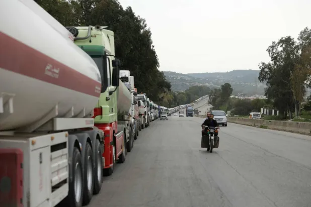 Long convoys of Iraqi diesel-laden tanker trucks line up along the Tartus-Baniyas highway as they wait to unload their cargo at the Baniyas port refinery on the Mediterranean Sea, on April 15, 2026. (Photo by Bakr ALkasem / AFP)