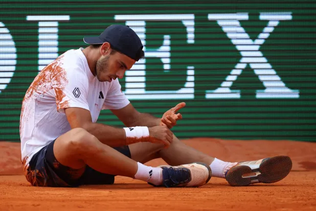 Argentinia's Francisco Cerundolo reacts after a fall as he plays against Greece's Stefanos Tsitsipas during the Monte Carlo ATP Masters Series Tournament round of 64 tennis match on Court Rainier III at the Monte-Carlo Country Club in Roquebrune-Cap-Martin, south-eastern France on April 6, 2026. (Photo by Valery HACHE / AFP)