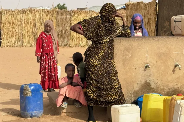  08 April 2026, Chad, Aboutengye: Women and girls wait for water distribution at the Aboutengue refugee camp in eastern Chad near the border with Sudan. Photo: Eva Krafczyk/dpa