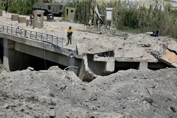 A man stands on a damaged part of the Qasmiyeh Bridge that was targeted by an Israeli airstrike near Tyre, southern Lebanon, 16 April 2026. EPA/STRINGER