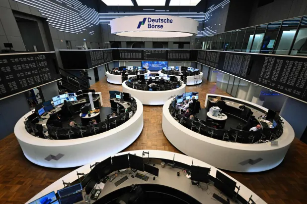 متداولون يعملون أمام شاشة تعرض مؤشر الأسهم الألماني «داكس» في بورصة فرانكفورت (أ.ف.ب)