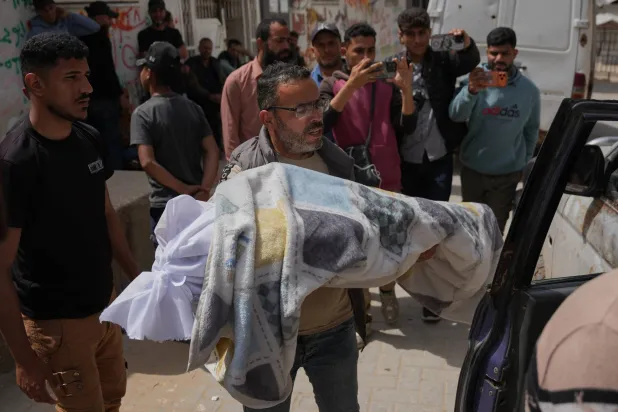 فلسطيني يحمل جثمان فتى (12 عاماً) قُتل برصاص إسرائيلي خلال تشييعه خارج «مستشفى الشفاء» بمدينة غزة الجمعة (أ.ب)