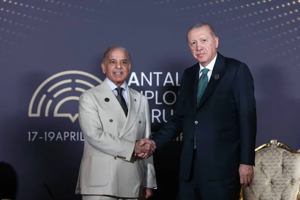 الرئيس التركي رجب طيب إردوغان مصافحاً رئيس وزراء باكستان شهباز شريف في مستهل لقائهما في أنطاليا جنوب تركيا الجمعة (الرئاسة التركية)