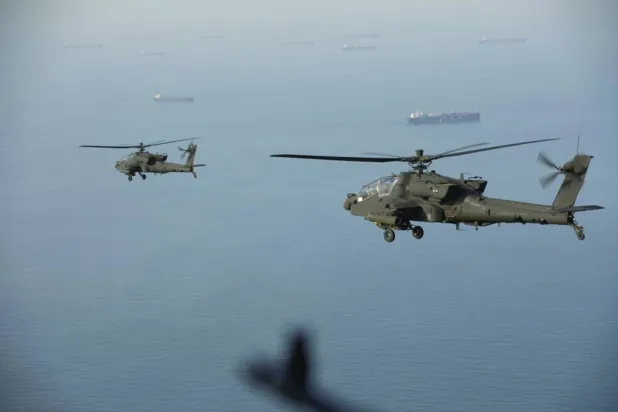 
مروحيتان هجوميتان أميركيتان من طراز «إيه إتش-64 أباتشي» تحلّقان فوق مضيق هرمز (سنتكوم)