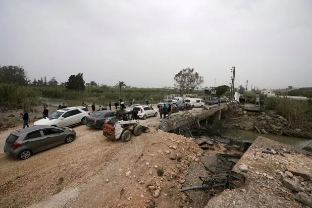 Displaced people cross a destroyed bridge which was hit few days ago in an Israeli airstrike, as they return to their villages on the second day of a ceasefire between Hezbollah and Israel in Qasmiyeh, near Tyre city, southern Lebanon, Saturday, April 18, 2026. (AP) 