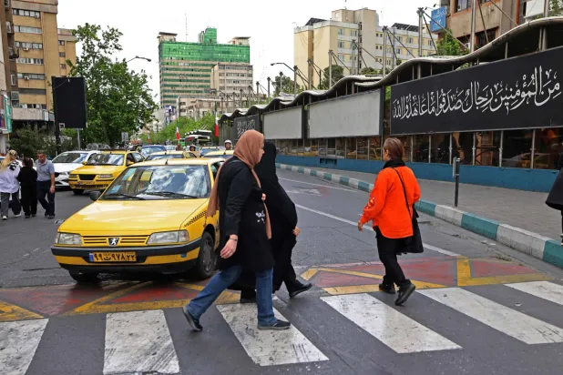 People walk through the Valiasr Square in Tehran on April 19, 2026. (AFP)