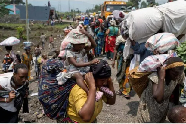 Goma yakınlarında M23 isyancıları ile Kongo ordusu arasında çıkan çatışmaların ardından köylerinden kaçarken eşyalarını taşıyan insanlar (Reuters)