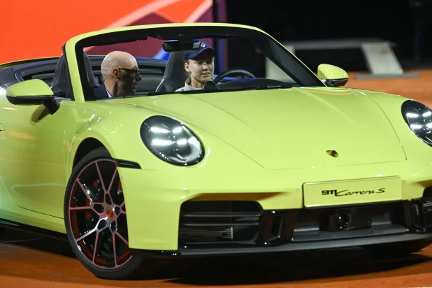  Kazakhstan's Elena Rybakina steers the winner's car next to Porsche CEO Michael Leiters after she won against Czech Republic's Karolina Muchova (not in picture) in the final match at the Women's Tennis Grand Prix WTA tournament in Stuttgart, southwestern Germany, on April 19, 2026. (AFP) 