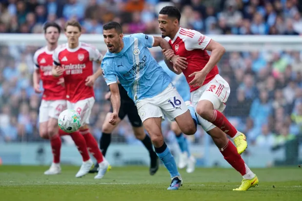 لاعب وسط مانشستر سيتي رودري يصارع على الكرة مع مدافع آرسنال ويليام ساليبا (أ.ب)