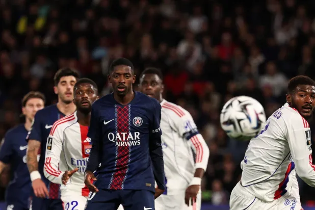 مهاجم باريس سان جيرمان عثمان ديمبيلي ومدافع أولمبيك ليون أينسلي ميتلاند نايلز يتابعان الكرة (أ.ف.ب)