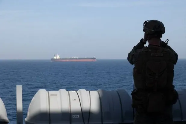 ABD Merkez Komutanlığı'na bağlı bir deniz piyadesi, İran limanları açıklarında uygulanan deniz ablukası sırasında gemi trafiğini izliyor