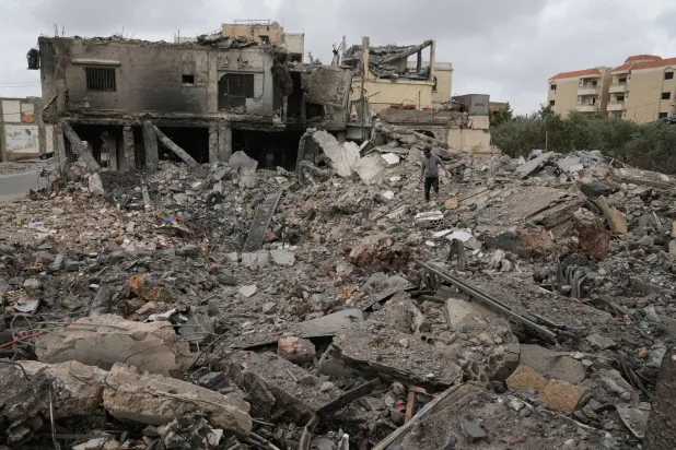 Mohammed Ameen walks on the rubble of a building destroyed in a previous Israeli airstrike during a ceasefire between Hezbollah and Israel in the Hosh neighborhood of Tyre, southern Lebanon, on Sunday, April 19, 2026. (AP)