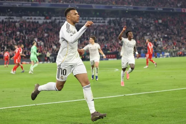 Real Madrid's French forward #10 Kylian Mbappe celebrates scoring the 2-3 goal with his teammates during the UEFA Champions League quarter-final second leg football match between FC Bayern Munich and Real Madrid in Munich, southern Germany, on April 15, 2026. (AFP) 