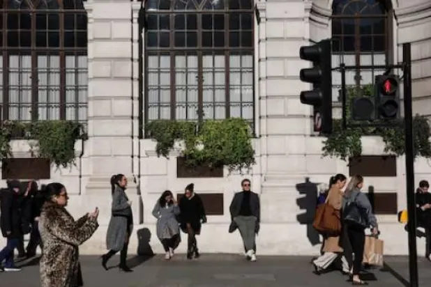 أشخاص يتنزهون في حي «سيتي أوف لندن» المالي (رويترز)