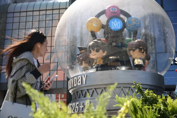 سيدة تسير في أحد شوارع الضاحية المالية في العاصمة الصينية بكين (إ.ب.أ)