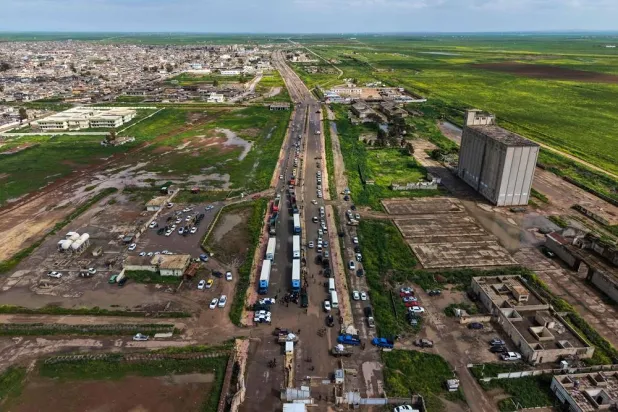 This aerial picture shows cars and trucks loaded with goods waiting to cross over into Syria at the al-Rabia border crossing on April 20, 2026. (AFP)