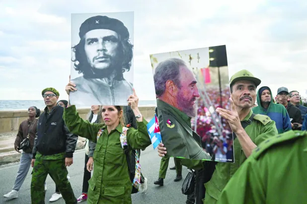 كوبيون يرفعون صورتَي تشي غيفارا والزعيم الكوبي الراحل فيديل كاسترو خلال مظاهرة «مناهضة للإمبريالية» أمام السفارة الأميركية في هافانا بتاريخ 16 يناير 2026 (أ.ف.ب)