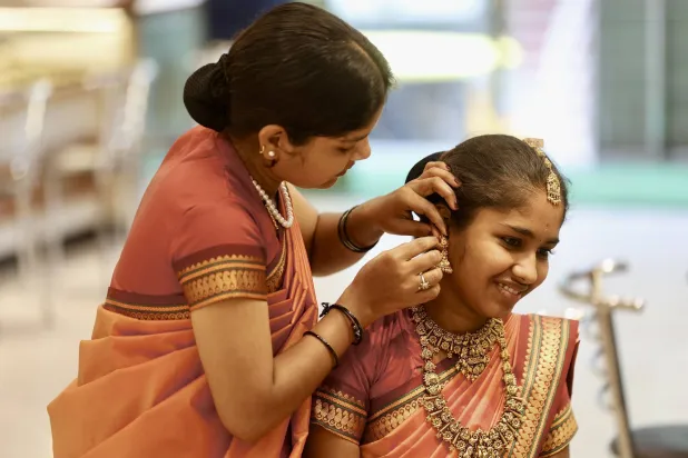 امرأة هندية ترتدي حلياً ذهبياً في متجر مجوهرات في بنغالور (إ.ب.أ)